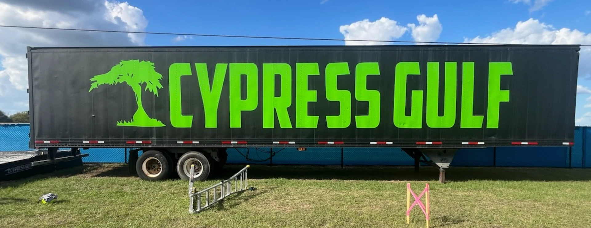 Semi-trailer with black and lime green Cypress Gulf vinyl wrap featuring cypress tree graphics by BAPS Signs & Wraps in Oldsmar, FL