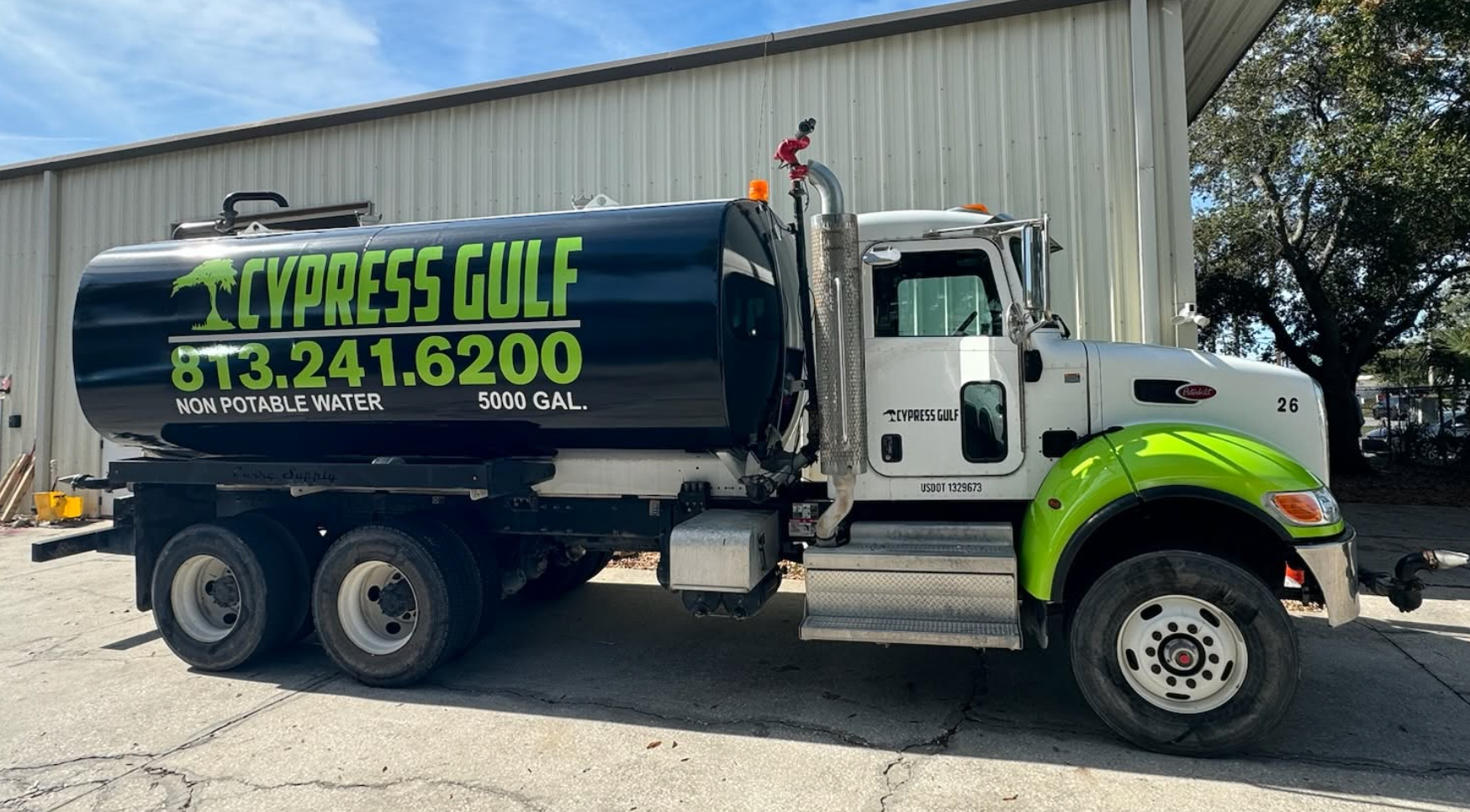 White Peterbilt water truck with black tank featuring neon green Cypress Gulf tree logo, lettering, phone number, and Non Potable Water 5000 GAL text in cut vinyl, installed by BAPS Signs & Wraps in Oldsmar, FL