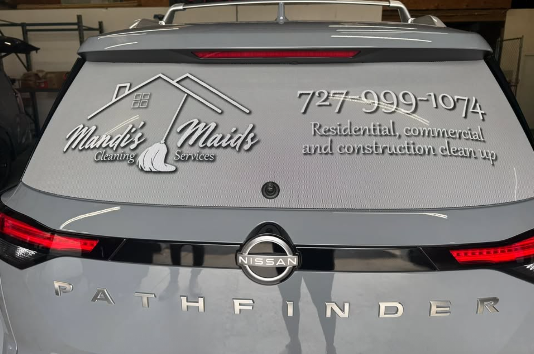 Grey Nissan Pathfinder SUV with perforated rear window vinyl graphic featuring Mandi's Maids Cleaning Services logo, phone number 727-999-1074, and service descriptions, installed by BAPS Signs & Wraps in Oldsmar, FL